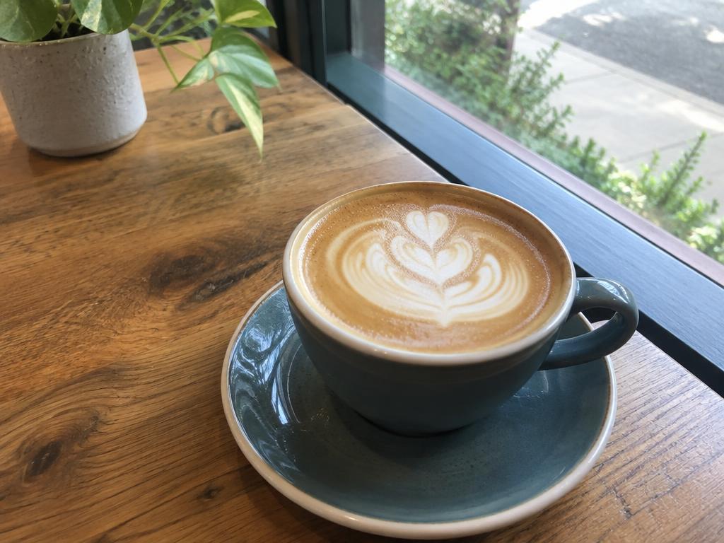 A casual photo of a latte on a café table, as posted to a social feed
